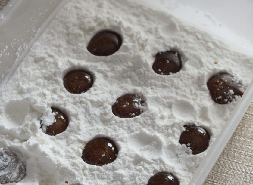 1. Этап. Леденцы без сахара: Формами для леденцов могут послужить силиконовые, но если таких нет, то можно воспользоваться пластиковым контейнером и крахмалом. В пластиковый контейнер насыпьте толстым слоем крахмал. Пальцем, на небольшом расстоянии друг от друга, сделайте углубления. В эти углубления капайте полученный медово-травяной сироп. Диаметр регулируйте по желанию, но за края углубления не выходите, т.к. сироп будет растекаться. Если в процессе сироп застынет, подогрейте его и продолжите разливать леденцы.