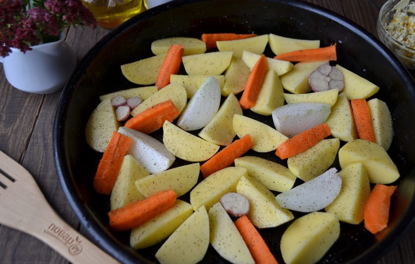 1. Этап. Жареный цыпленок целиком: Для запекания выберите глубокий и большой противень. Очистите и порежьте овощи, слишком мелко резать не нужно, ведь они будут в духовке долго. Чеснок очищать не нужно, вымойте головку и порежьте ее вдоль на две части. Распределите овощи, посолите, присыпьте перцем (черным молотым).