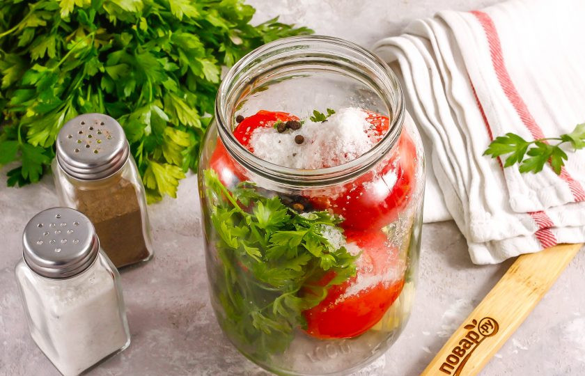 1. Этап. Розовые помидоры на зиму: Вскипятите воду. Всыпьте в банку соль, горошины черного перца, выложите промытые веточки петрушки или сельдерея. Влейте уксус.