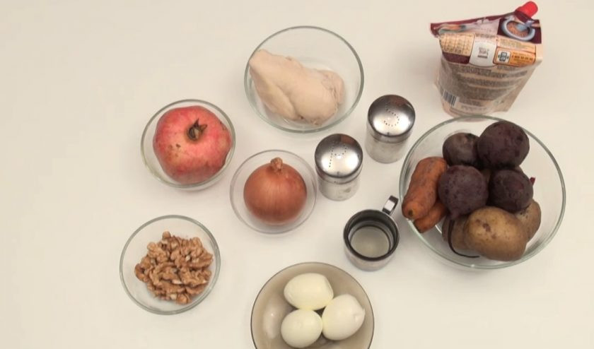 1. Этап. Гранатовый браслет рецепт классический: Натрите на крупной терке очищенный картофель, морковь, свеклу и яйца. Куриное филе нарежьте кубиками. Лук нужно нарезать и обжарить на растительном масле. Дальше нужно измельчить орехи, из граната извлечь зернышки. Возьмите тарелку, в центре поместите стакан. И теперь вокруг стакана выкладывайте ингредиенты.