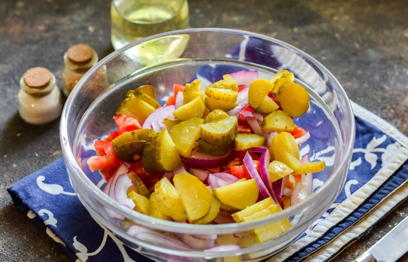 1. Этап. Селянский салат: Маринованные огурцы нарежьте небольшими кубиками или дольками. Добавьте огурцы в салат.