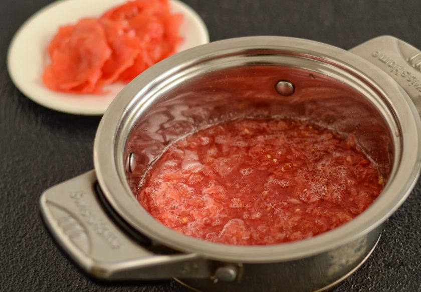 1. Этап. Соус «Краснодарский»: Помидор нарежьте на четвертинки, затем натрите на крупной терке так, чтобы кожура осталась в руках (её мы использовать не будем). Поставьте томатное пюре нагреваться на среднем огне.