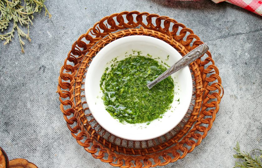 1. Этап. Чесночные булочки в духовке из дрожжевого теста: Зелень мелко порежьте и смешайте с растительным маслом, измельченным чесноком и одной столовой ложкой воды. Все посолите и хорошо перемешайте.