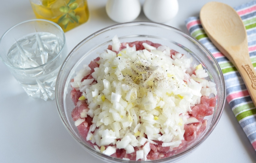 1. Этап. Беляши классические: Пока тесто подходит, нужно сделать фарш для беляшей. Очистите лук, порежьте его максимально мелко. К мясному фаршу добавьте лук, соль, перец черный молотый и холодную воду. Хорошо перемешайте фарш.