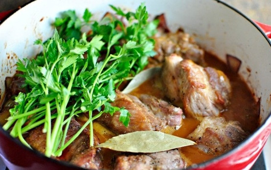 1. Этап. Свиная шейка тушеная: Теперь возвращаем в блюдо куски обжаренной свинины. Заливаем все это дело бульном (если его нет - можно просто водой), добавляем свежей зелени и лаврового листа. Накрываем крышкой, уменьшаем огонь и тушим около 3 часов.