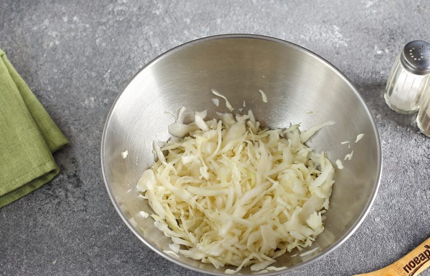 1. Этап. Салат с яйцом, капустой и колбасой: Капусту тонко нашинкуйте. Добавьте щепотку соли и помните руками, чтобы она стала мягче (если у вас капуста молодая, то можно пропустить этот шаг).