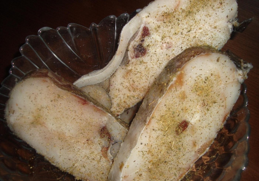 1. Этап. Треска под сметанным соусом: 1. Стейки треки промываю, обтираю бумажными салфетками и перекладываю в миску, солю, по вкусу добавляю черный молотый перец и хмели-сунели. Стейки обваливаю в муке и обжариваю на раскаленной сковороде (по 3 минуты с каждой стороны).