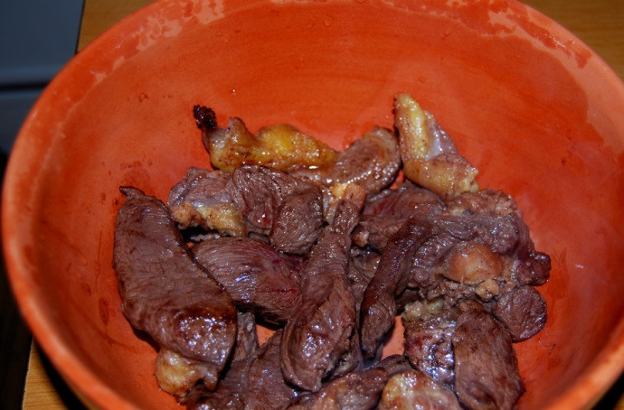 1. Этап. Конина в духовке: Пока мясо обжаривается, картошку почистите и порежьте тонкими пластинами. Затем обжаренное мясо выложите в подготовленный керамический горшочек, в котором мы и будем запекать конину.