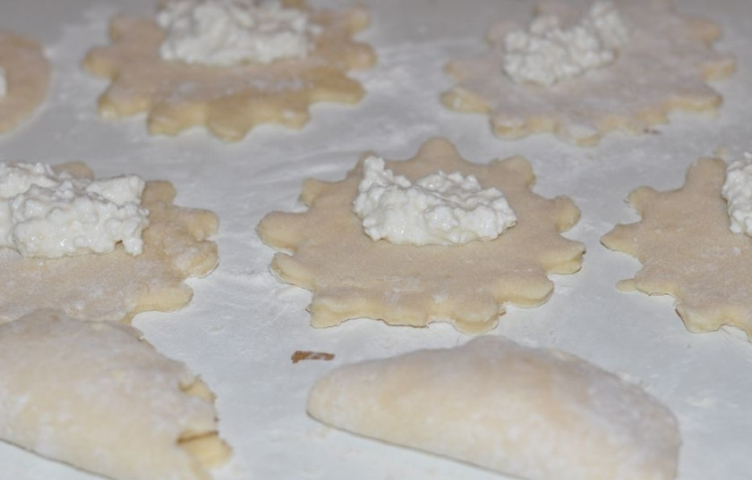 1. Этап. Сочень с творогом: Тесто раскатайте, вырежьте из него кружочки диаметром приблизительно 10 см., можете взять для этих целей формы для кексов, тогда края будут ребристыми. Выложите на одну половину немного творожной начинки, накройте сочники другой половиной. Не стоит усердно закрывать края, начинка должна немного проглядывать и выходить наружу. Смажьте взбитым яйцом, чтобы сочники были красивого румяного цвета. Отправьте в разогретую до 200 градусов духовку на 20-25 минут.