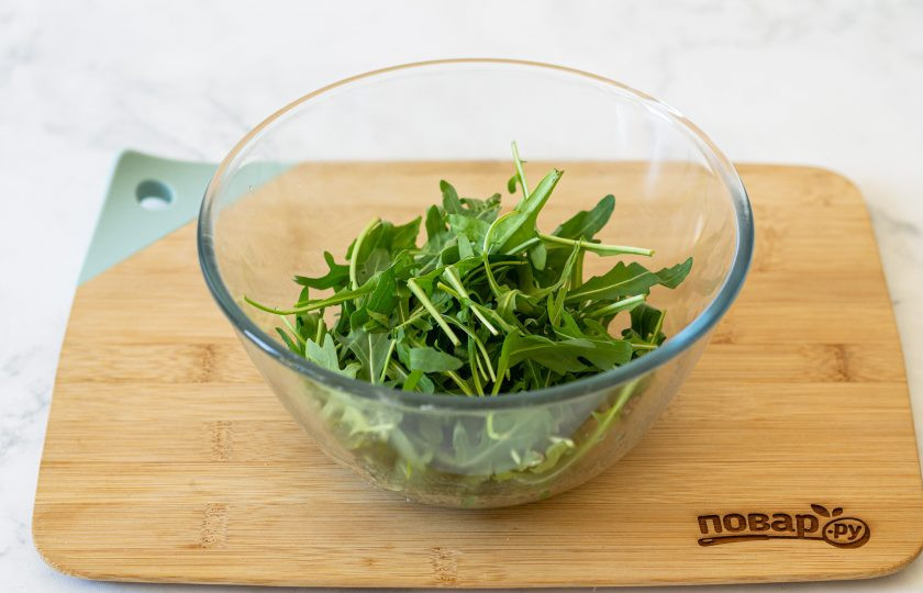 1. Этап. Салат с рукколой и мандаринами: Добавьте в миску рукколу. Аккуратно перемешайте.