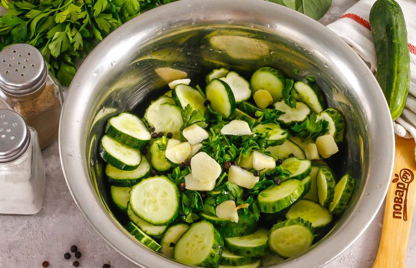 1. Этап. Малосольные огурцы в вакууме: Очистите зубчики чеснока от шелухи и промойте в воде вместе с петрушкой. Петрушку измельчите или замените укропом. Чеснок нарежьте слайсами. Добавьте в емкость к огурцам вместе с горошинами черного перца.
