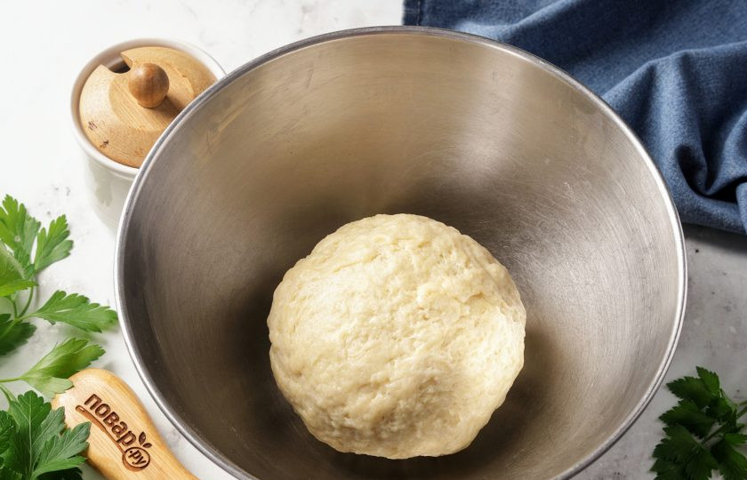 1. Этап. Пирожки на сметане в духовке: Замесите мягкое пластичное тесто. Заверните в пищевую плёнку и уберите в морозилку на 15 минут.