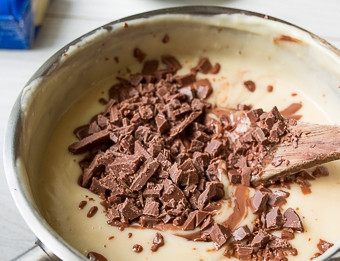 1. Этап. Вафельные трубочки с кремом: Далее поставьте будущий крем в кастрюльке на сильный огонь. Доведите его до кипения, постоянно помешивая, и сразу выключите. Добавьте 75 г. масла небольшими порциями, а потом всыпьте измельчённый шоколад. Перемешайте и остудите крем.