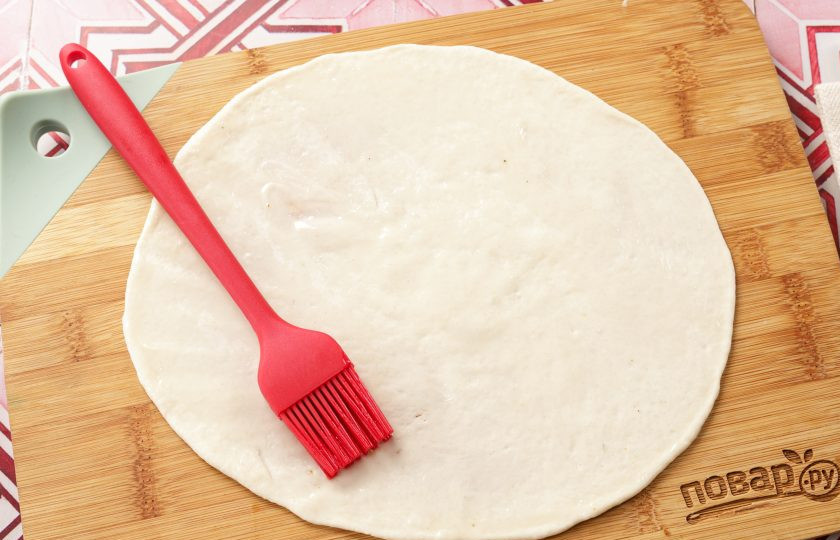 1. Этап. Ютаза: Раскатанное тесто смазываем растительным маслом и вытягиваем руками в очень тонкий пласт.