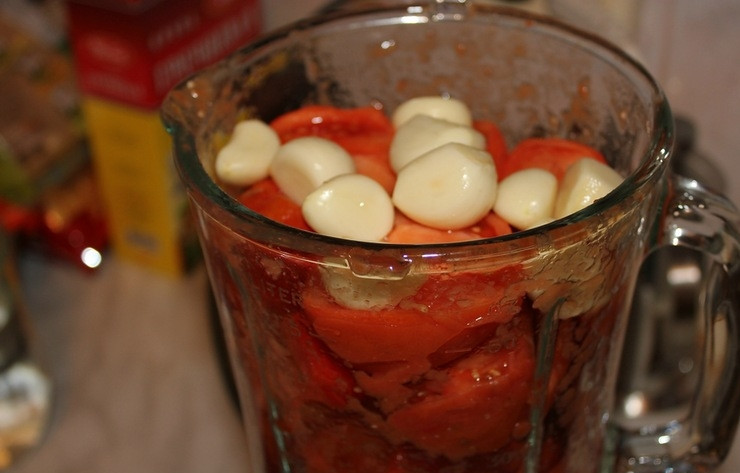 1. Этап. Холодный томатный суп: Для начала тщательно вымойте помидоры, разрежьте их на четверти, не забыв убрать жёсткую сердцевину, если она имеется. Очистите зубчики чеснока. Сложите помидоры и чеснок в блендер, добавьте оливковое масло и превратите овощи в пюре.