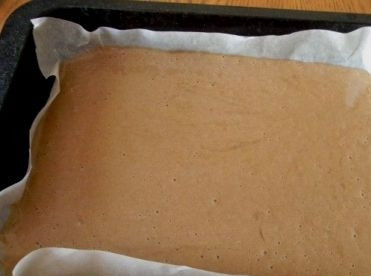 1. Этап. Шоколадный рулет с творожным кремом: Застилаем противень пергаментом и выливаем на него тесто.