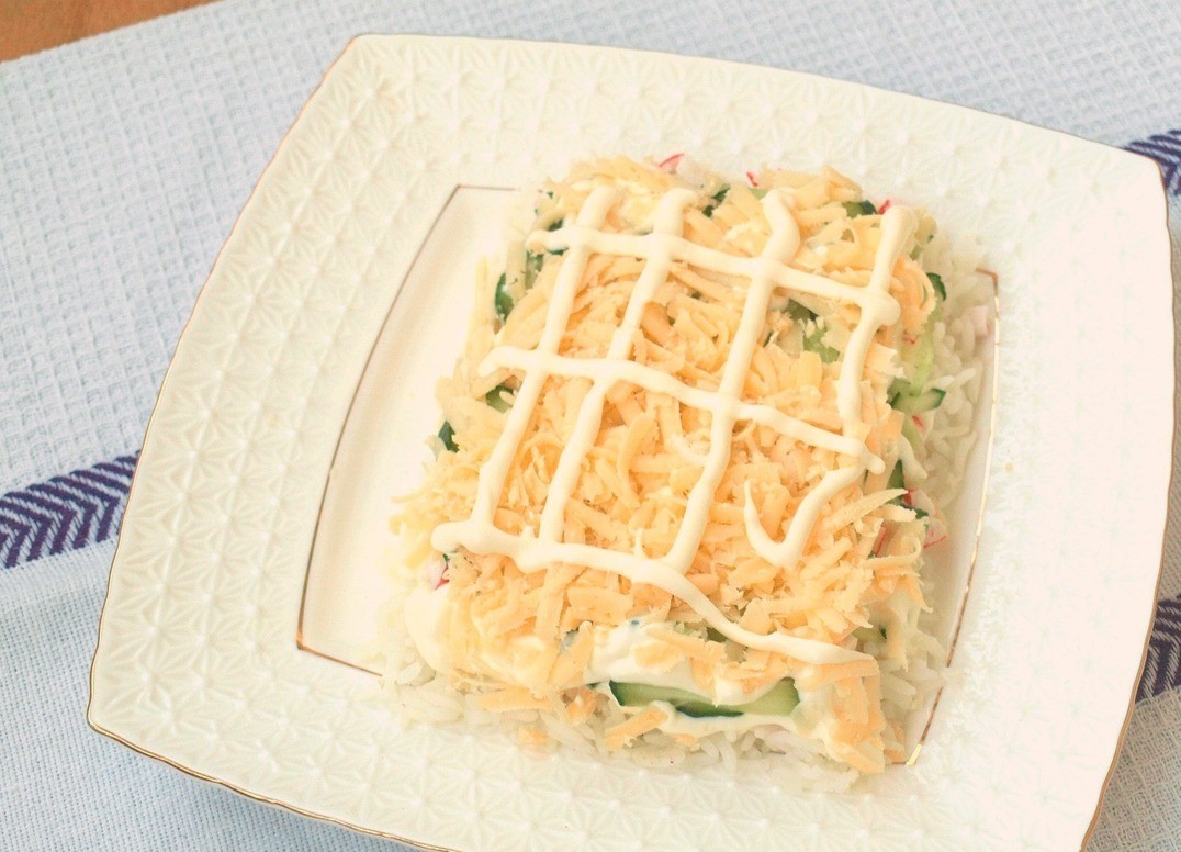 1. Этап. Салат Новогодний календарь: Натереть твёрдый сыр, посыпать его сверху огурчиков, нанести майонез.