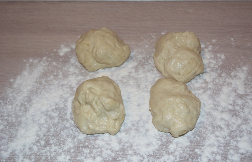 1. Этап. Булочки с мясом в духовке: Начинку охладите. Достаньте тесто. Разделите его на несколько кусочков. Стол присыпьте мукой. Каждый кусочек теста прижмите руками.