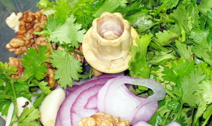 1. Этап. Пхали из баклажанов: Теперь создадим заправку для баклажанов. Для этого в чашу блендера выкладываем промытую кинзу, грецкие орехи, нарезанный лук, зубчики чеснока, соль, уксус и все специи. Несколько колец лука оставляем для украшения. Перемалываем ингредиенты несколькими движениями, чтобы они не превратились в месиво.