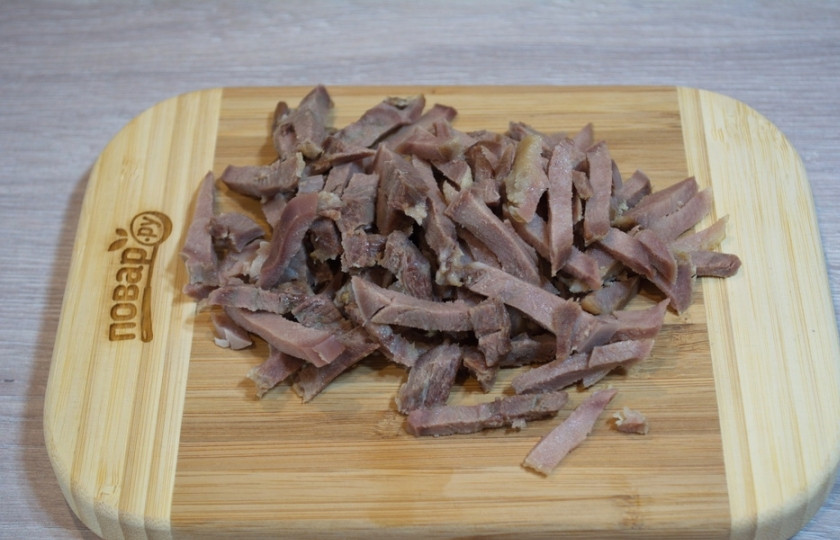 1. Этап. Салат с языком и шампиньонами: Для приготовления салата с языком и шампиньонами нам необходимо взять отварной язык. Язык нарежьте небольшими полосочками.