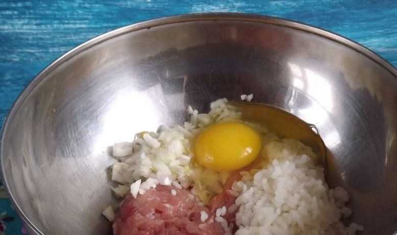 1. Этап. Простой рецепт ленивых голубцов: В глубокую миску выложите готовый фарш, добавьте к нему заранее отваренный рис, мелко нарубленный репчатый лук и вбейте сырое куриное яйцо.