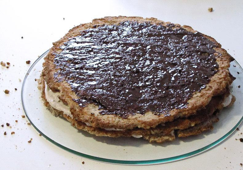 1. Этап. Итальянский ореховый торт: Для начинки растопите на паровой бане черный шоколад, соедините его со сливками. Смажьте этой смесью каждый коржик, а затем сложите их друг на друга, чтобы получился торт.