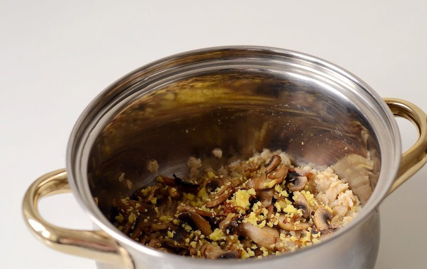 1. Этап. Овсянка с грибами: Добавьте натертый сыр, жареный лук и грибы. Аккуратно перемешайте. Прогрейте, пока сыр не расплавится, затем снимите кашу с плиты.