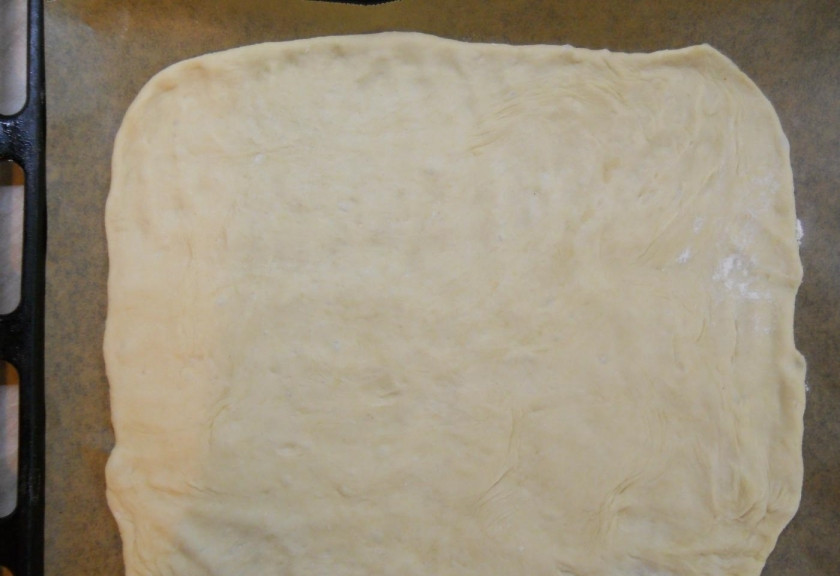 1. Этап. Вкуснейший сырный пирог: 5. Одну часть теста (та, что больше) раскатываю в пласт толщиной около 3 миллиметров. Противень застилаю пергаментом, перекладываю на него тесто.