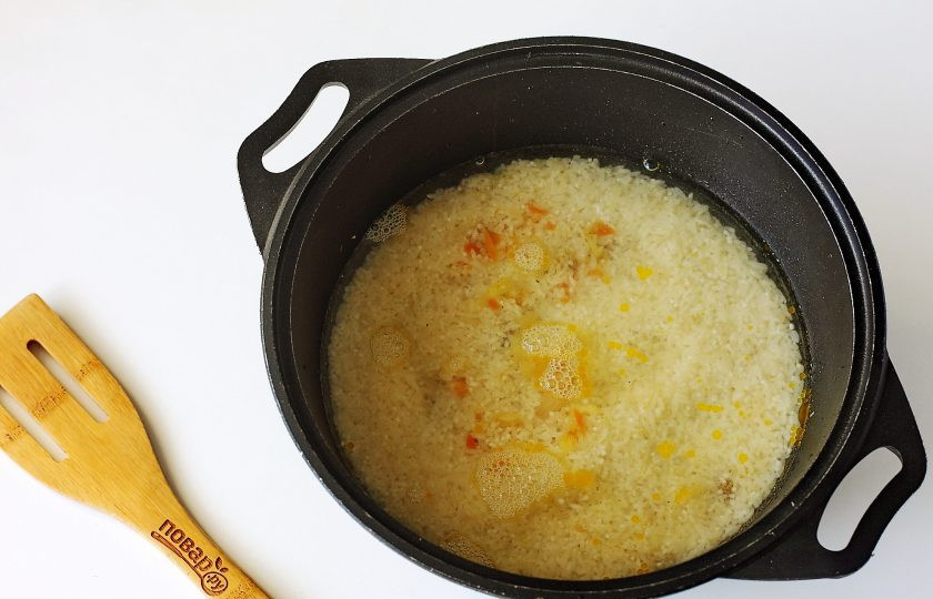 1. Этап. Рис с квашеной капустой и мясом: Распределите рис ровным слоем (не перемешиваем). Налейте горячую воду. Вода должна быть примерно на 1 см. выше крупы. Добавьте по вкусу соль, накройте казан крышкой и на небольшом огне тушите до полной готовности риса.