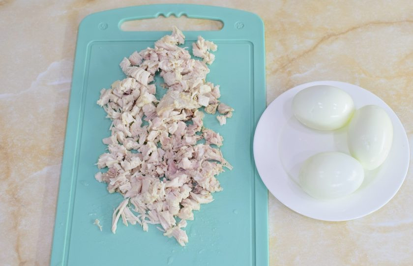 1. Этап. Салат с курицей, сыром и маринованными грибами: Остывшие яйца очистите от скорлупы. Куриное мясо нарежьте небольшими кубиками.