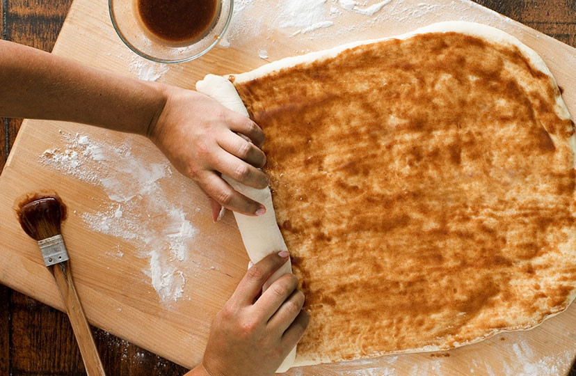 1. Этап. Улитка с корицей (оригинальный рецепт): В отдельной емкости смешиваем коричневый сахар, корицу и сливочное масло до однородности. Распределяем эту смесь по поверхности теста. Аккуратно начинаем сворачивать тесто в рулет.