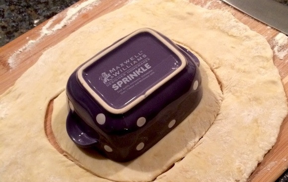 1. Этап. Куриный пирог в горшочке: 9. Посыпьте столешницу мукой и выложите тесто, раскатайте его в пласт, но не очень тонкий. Уложите горшочек и вырежьте по форме немного больше него, чтобы можно было сделать для него 