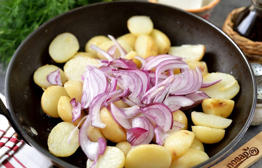 1. Этап. Картофель по-деревенски с фетой и красным луком: Проколите ломтик картофеля ножом, он должен быть почти готовым. Добавьте в сковороду нарезанный тонкими полукольцами красный лук, жарьте еще минуты 3.