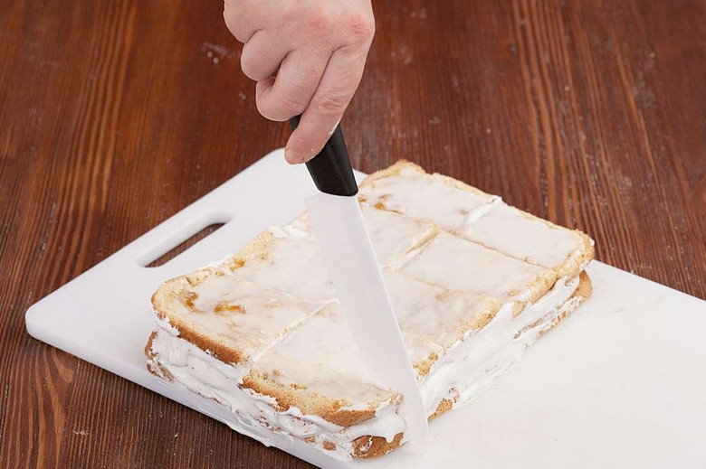 1. Этап. Бисквитное пирожное с белковым кремом: Нарезаем бисквит порционными кусочками. Боковую сторону каждого пирожного присыпаем крошками.