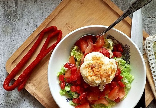 1. Этап. Овощной салат с колбасными снеками: Выкладываем майонез. Выдавливаем на него чеснок и добавляем красный жгучий перец.