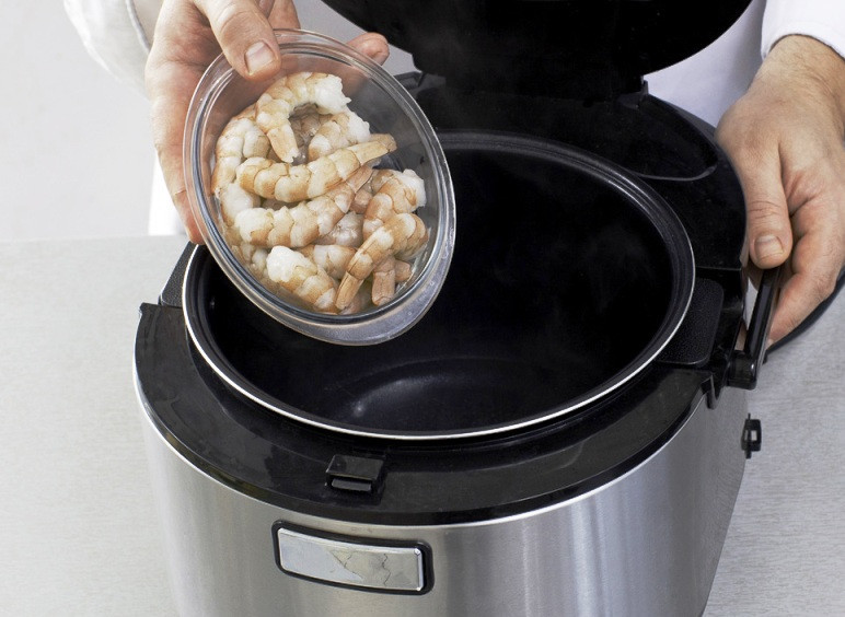 1. Этап. Простой суп из морепродуктов в мультиварке: Доведите до кипения воду в мультиварке и отварите в течение 5 минут креветки, затем откиньте их ну дуршлаг. Порежьте огурец, лук и маслины.