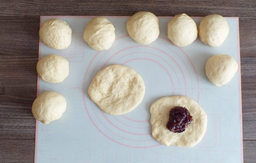 1. Этап. Пирожки с повидлом на кефире: Каждую часть разомните в лепешку с диаметром 11-12 см. На середину заготовки выложите столовую ложку без горки повидла.