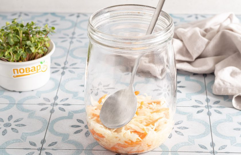 1. Этап. Квашеная капуста классическая в банке: Затем начните укладывать капусту в чистую банку слоями. Каждый небольшой слой тщательно утрамбовывайте ложкой, чтобы капуста была покрыта соком, который выделила.