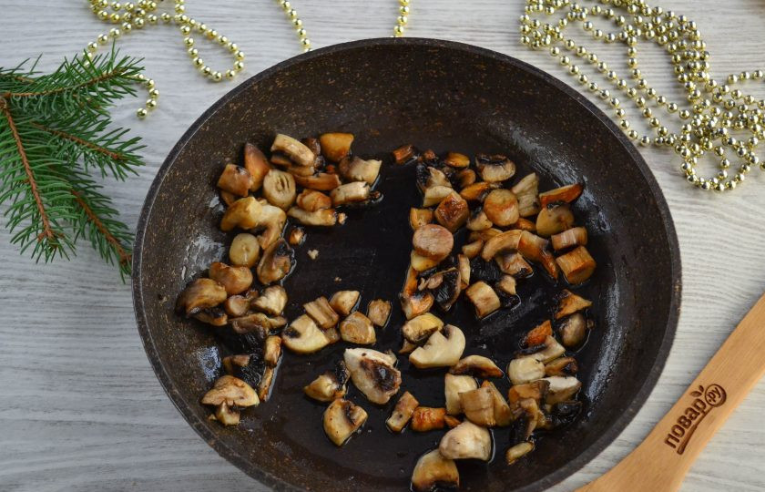 1. Этап. Слоеный салат «Мышка» с грибами и сыром: Обжарьте грибы в минимальном количестве растительного масла. Нужно, чтобы грибы не приставали к сковороде, но при этом оставались максимально сухими. Обжаривайте грибы до готовности. Не забудьте присолить и поперчить по вкусу.