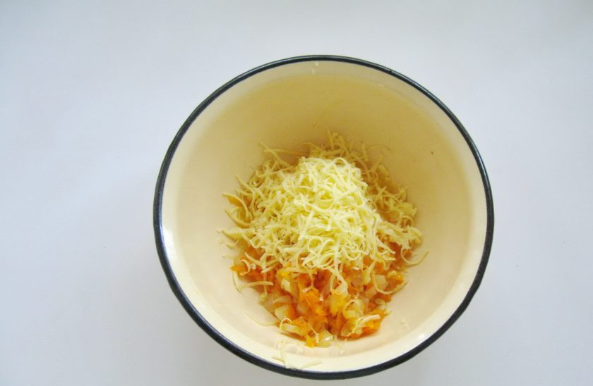 1. Этап. Куриные зразы с морковью и сыром: Жареные овощи переложите в миску и добавьте тертый сыр. Перемешайте, начинка для зраз готова.