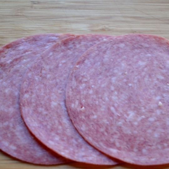 1. Этап. Роллы по-русски: Внахлест выкладываем несколько тонких ломтиков салями.