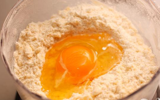 1. Этап. Тарталетки с песто и креветками: 1. Просеиваем муку и высыпаем ее в блендер, добавляем соли и нарезанное кубиками сильно охлажденное масло. Несколько секунд все перемешиваем в блендере. Должна получиться смесь напоминающая крошку. Не стоит измельчать очень сильно. В эту смесь добавляем яйцо и быстренько перемешиваем, тесто не должно успеть нагреться.