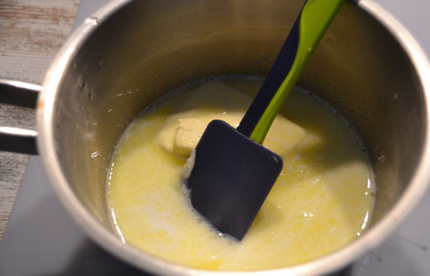 1. Этап. Эклеры со сметанным кремом: Добавьте 100 грамм сливочного масла, чтобы оно полностью растаяло.