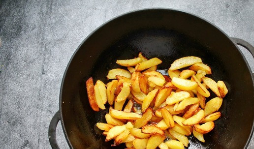 1. Этап. Картофель Бэби с дымком: В чугунную глубокую сковороду или как я в вок, налейте растительное масло и разогрейте на среднем огне. Картофель почистите, сплосните, обсушите и порежьте вдоль на дольки. Положите дольки в масло и обжаривайте, чтобы картошка была почти готовой.