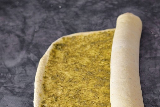 1. Этап. Лимонные булочки с песто: Готовое к работе тесто раскатайте в прямоугольник на подпыленной мукой поверхности. Размер прямоугольника примерно 30*40 см. Смажьте пласт теста соусом песто равномерно по всей поверхности. И сверните рулетом.