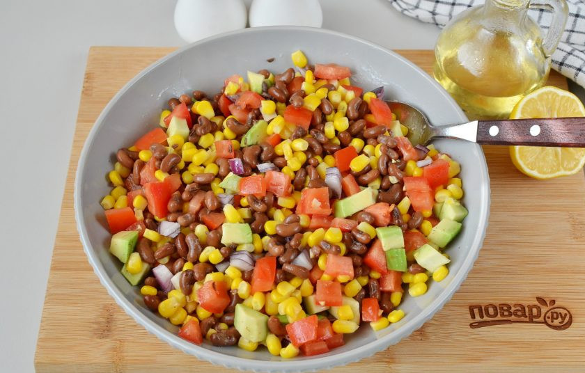 1. Этап. Овощной салат с фасолью и кукурузой: Добавьте соль, перец, растительное масло и перемешайте салат.