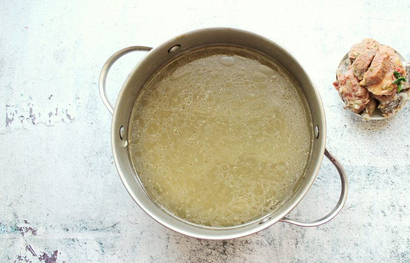 1. Этап. Щи старорусские: Спустя время достаньте из кастрюли кость и остудите. Бульон процедите, отварные овощи нам не понадобятся. С кости снимите отварное мясо.