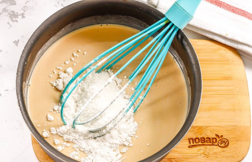 1. Этап. Крем из ряженки: Всыпьте просеянную пшеничную муку и вмешайте ее в молочную массу. Поместите емкость на плиту.