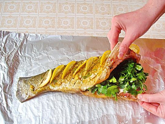 1. Этап. Запеченный толстолоб с лимоном и зеленью: 3. Помоем петрушку, дадим воде стечь, и вместе с дольками чеснока и ломтиками лимона положим в брюшко рыбы.