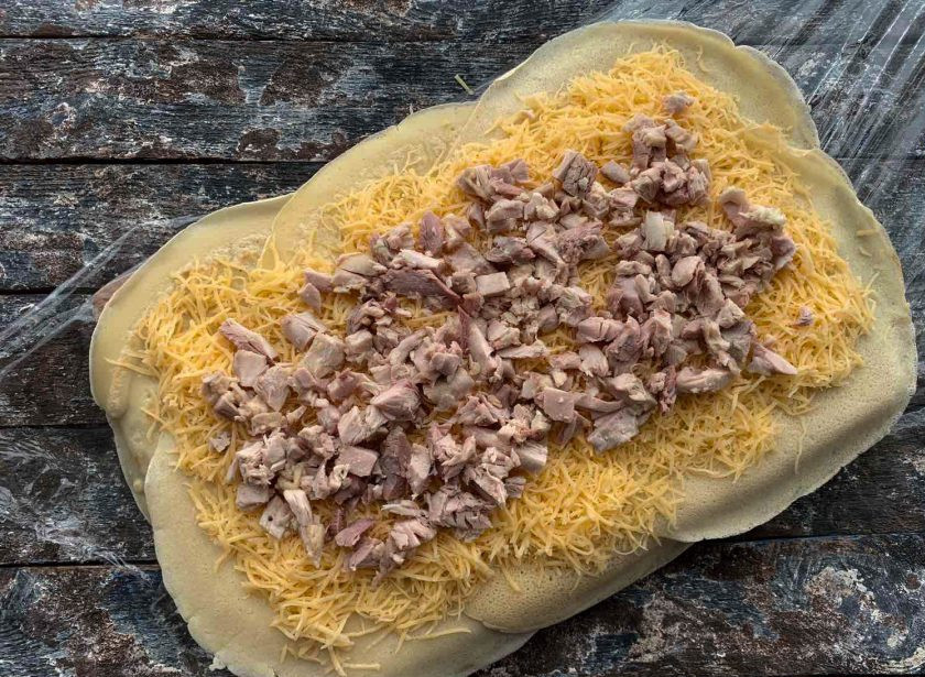 1. Этап. Блинный рулет с сыром: Сверху выложите нарезанную на маленькие кусочки вареную курицу.